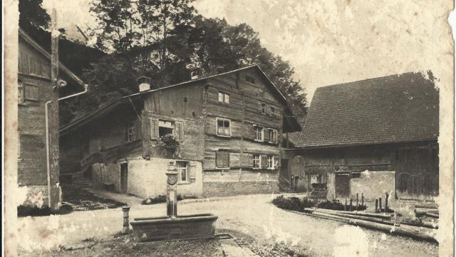 Dorfbrunnen mit altem Gemeindehaus